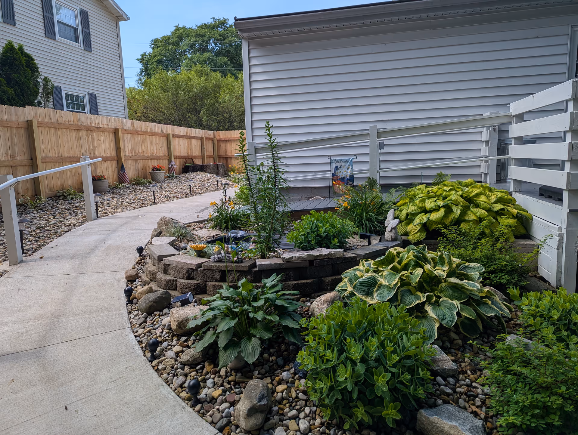 A landscaped outdoor garden with a curved concrete path beside the Serene Ridge building.