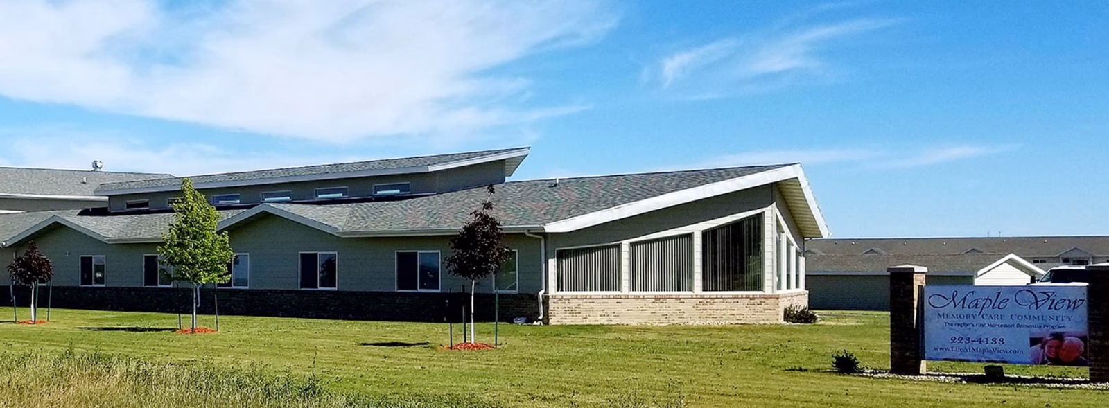 Exterior of Maple View Memory Care facility with a sloped roof and front sign.