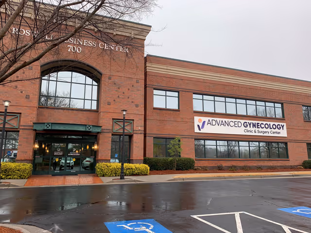 Brick exterior of a business center with Advanced Gynecology sign and glass doors