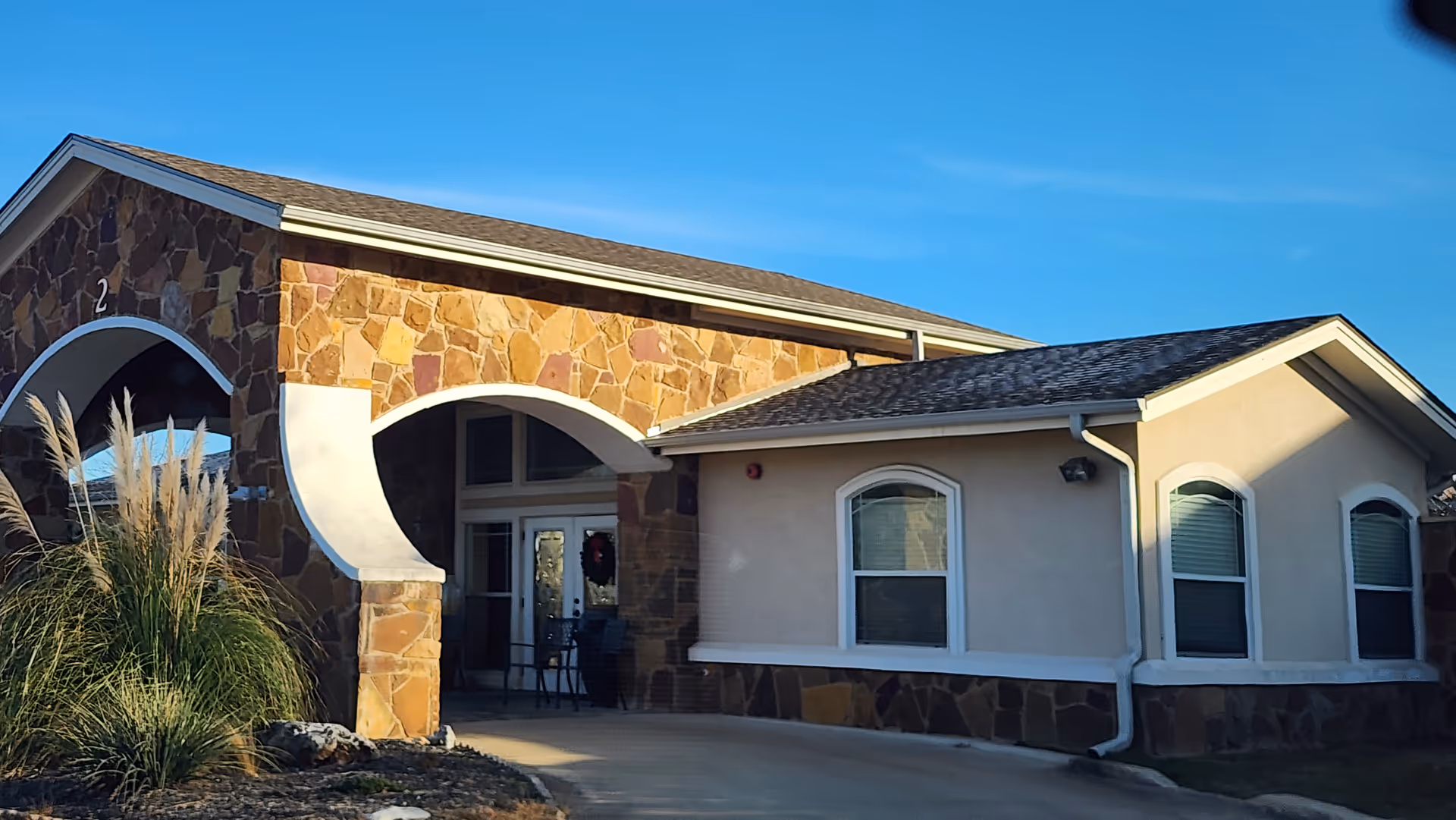 Exterior view of Georgetown Living facility with stone facade and curved entrance arch.
