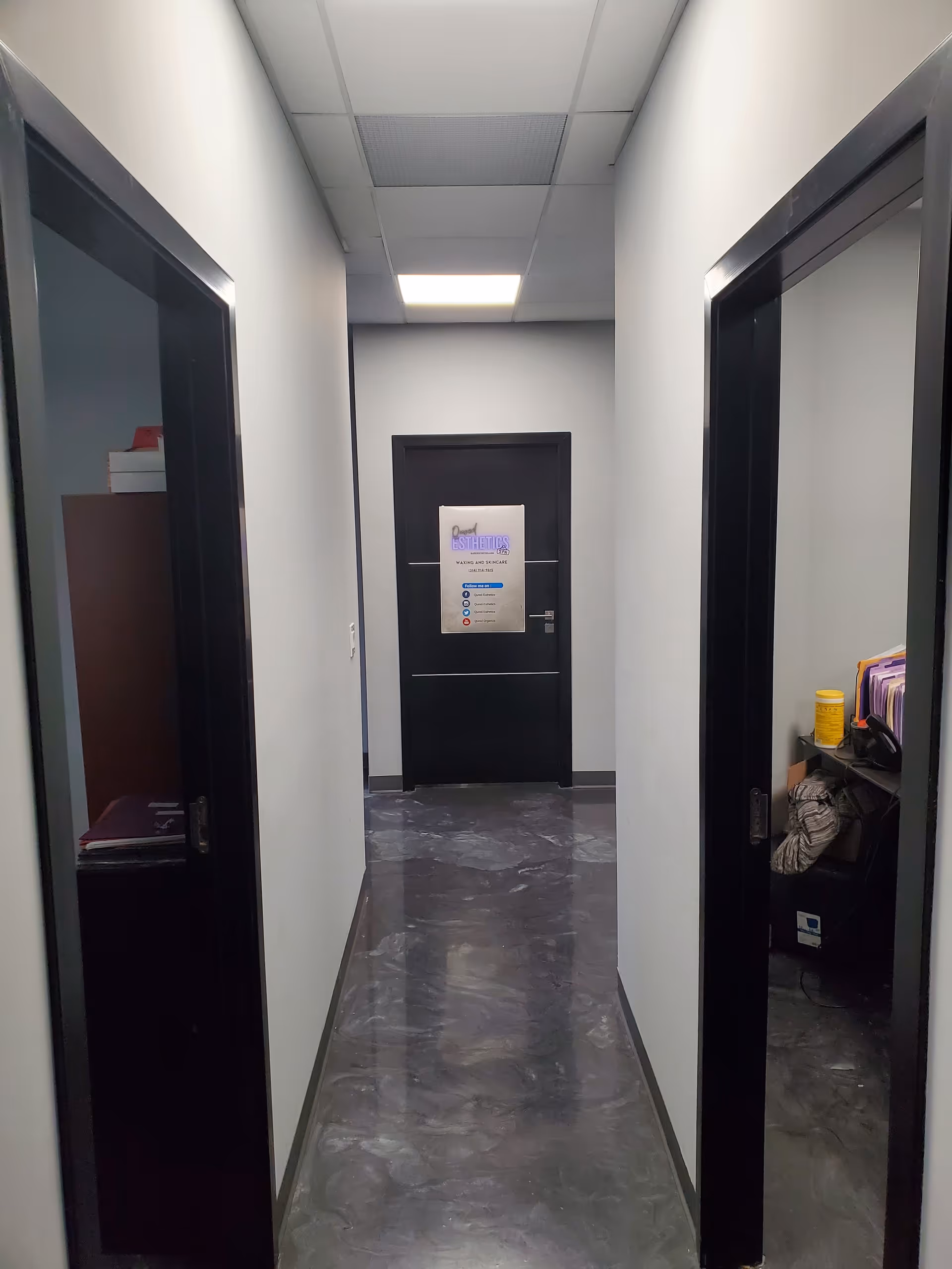 A narrow, glossy hallway with doors on both sides and a back door at the end.