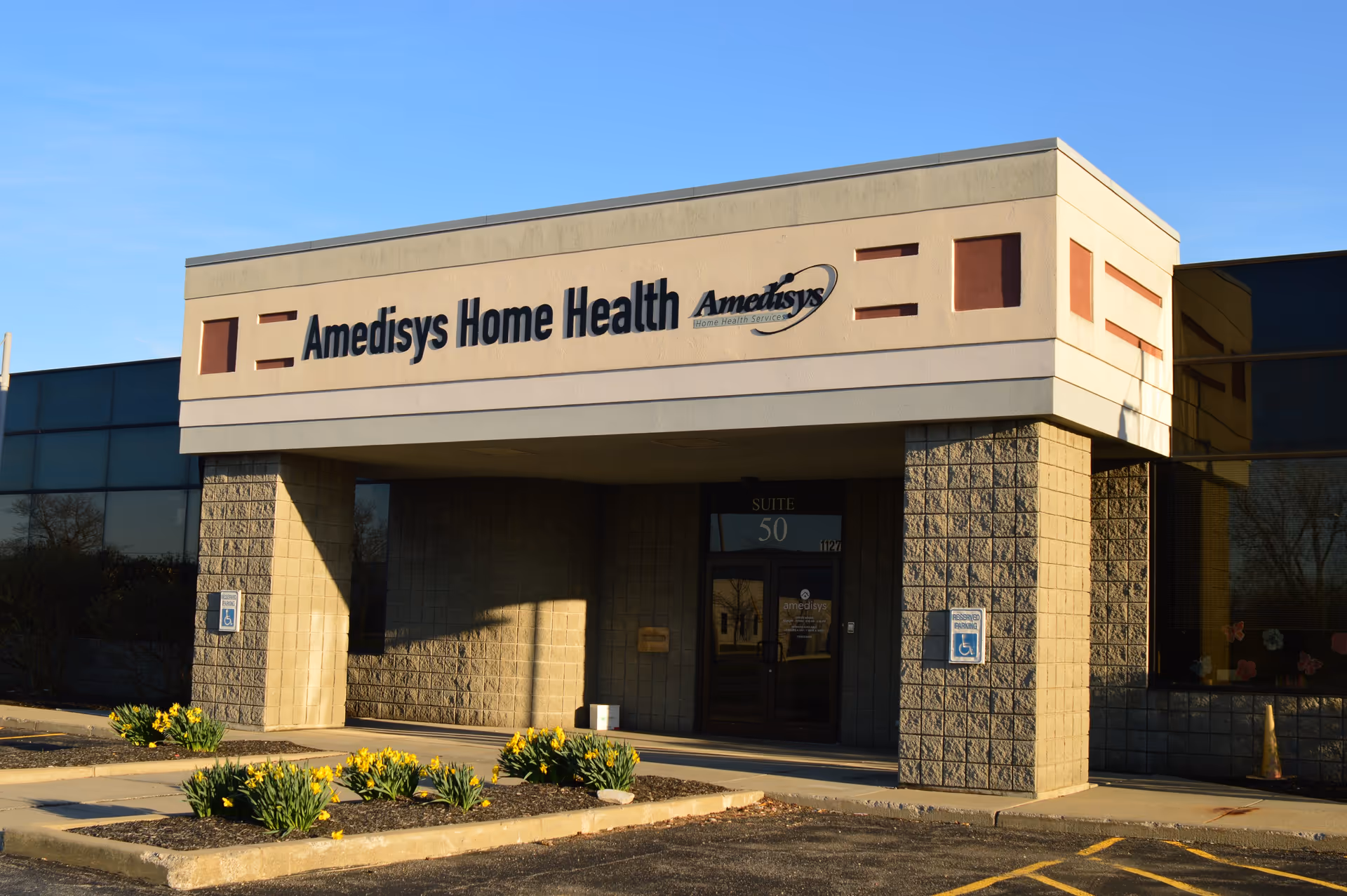 Exterior view of a beige Amedisys Home Health Care building with signage.