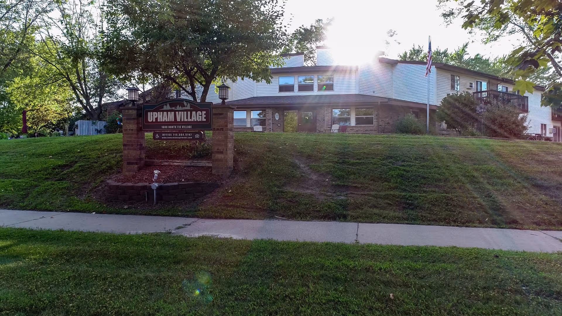Exterior view of Upham Village & Townhouses with sign and a two-story building.