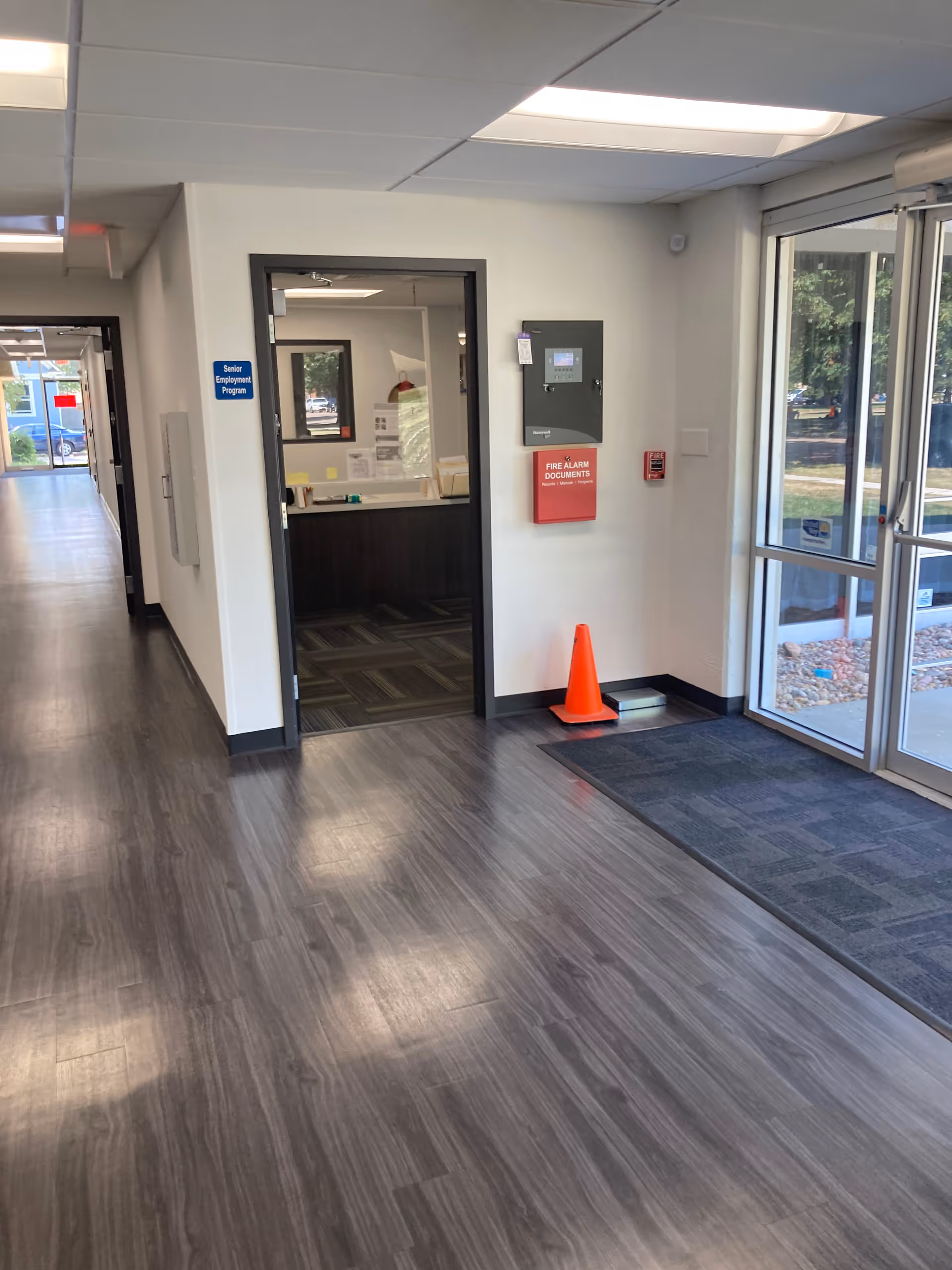 Interior hallway of Senior Services Inc of Wichita with glass entry doors and a reception area.
