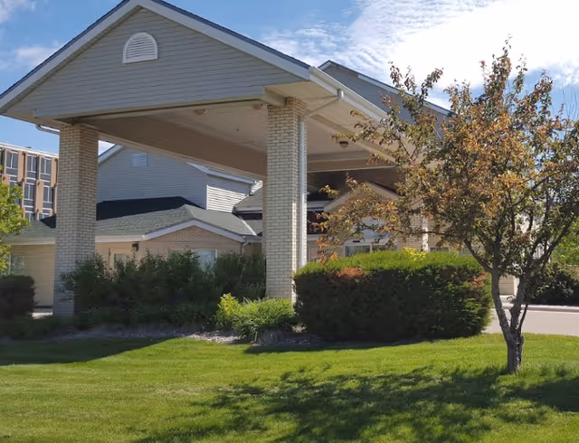 Exterior view of Golden Eagle Plaza entrance with a covered drive and landscaped lawn.