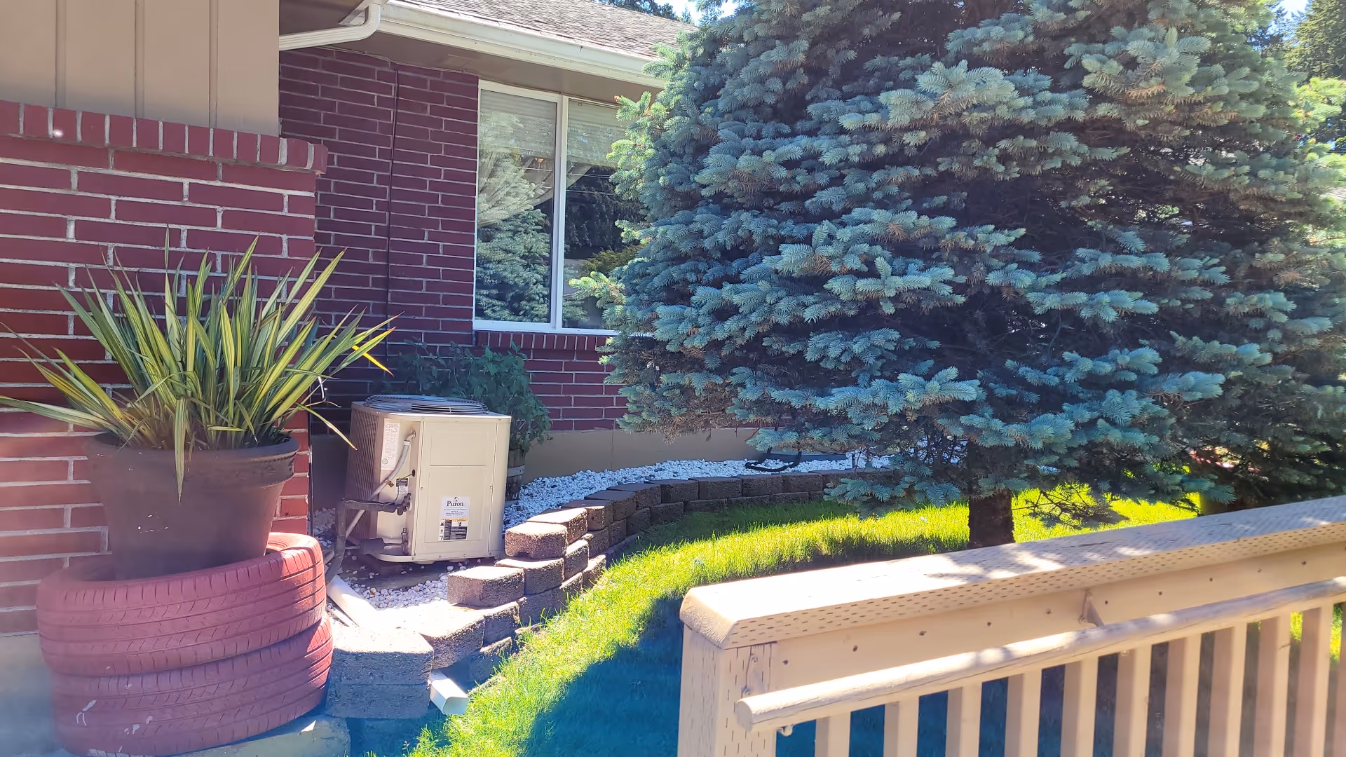 Exterior view of Annie's Pointe Adult Family Home with brick walls, potted plant, and trees.