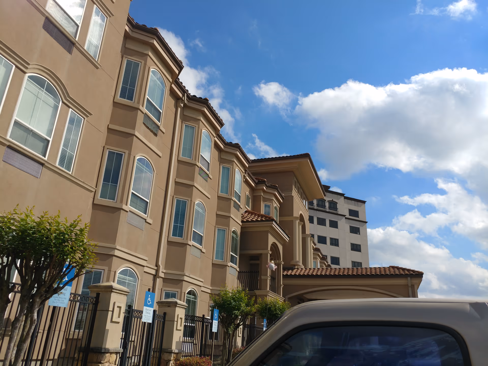 Exterior view of The Hampton at Meadows Place building against a blue sky.