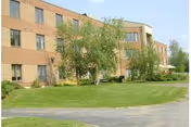 Two-story brick Norwich Rehabilitation and Nursing Center exterior with lawn and trees.