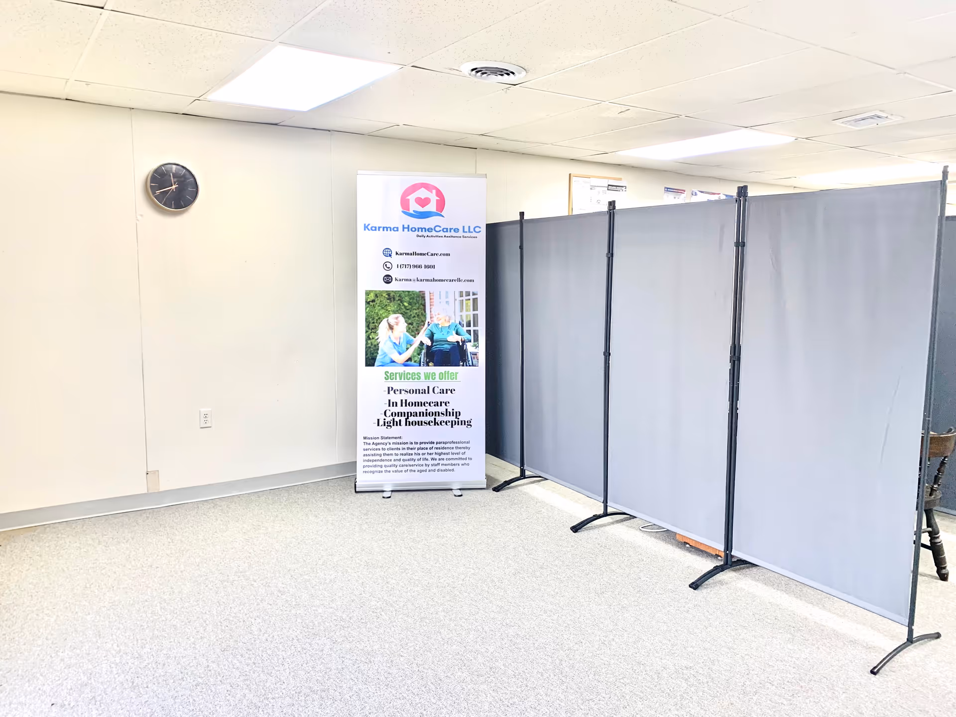Interior room with a Karma HomeCare banner and gray privacy screens.
