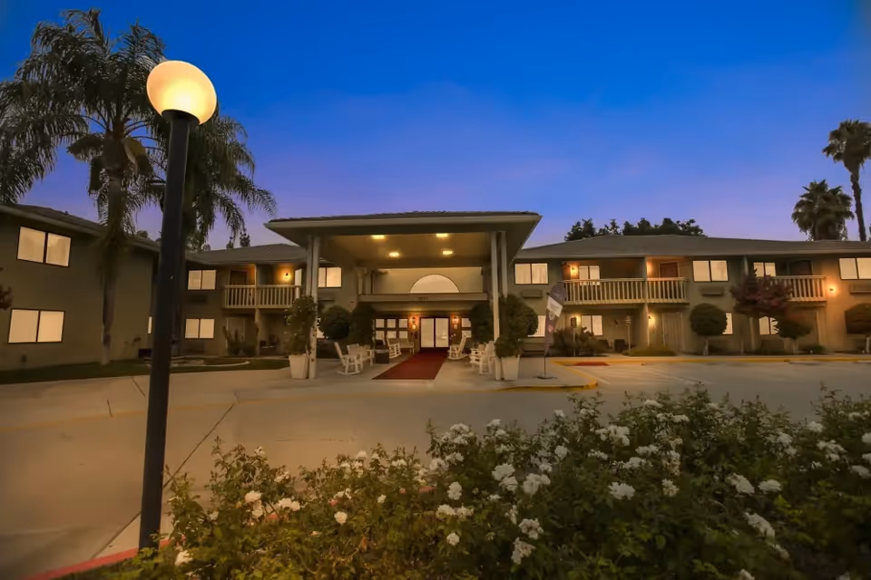 Exterior view of Truewood by Merrill in West Covina, building entrance surrounded by lighting and landscaping.