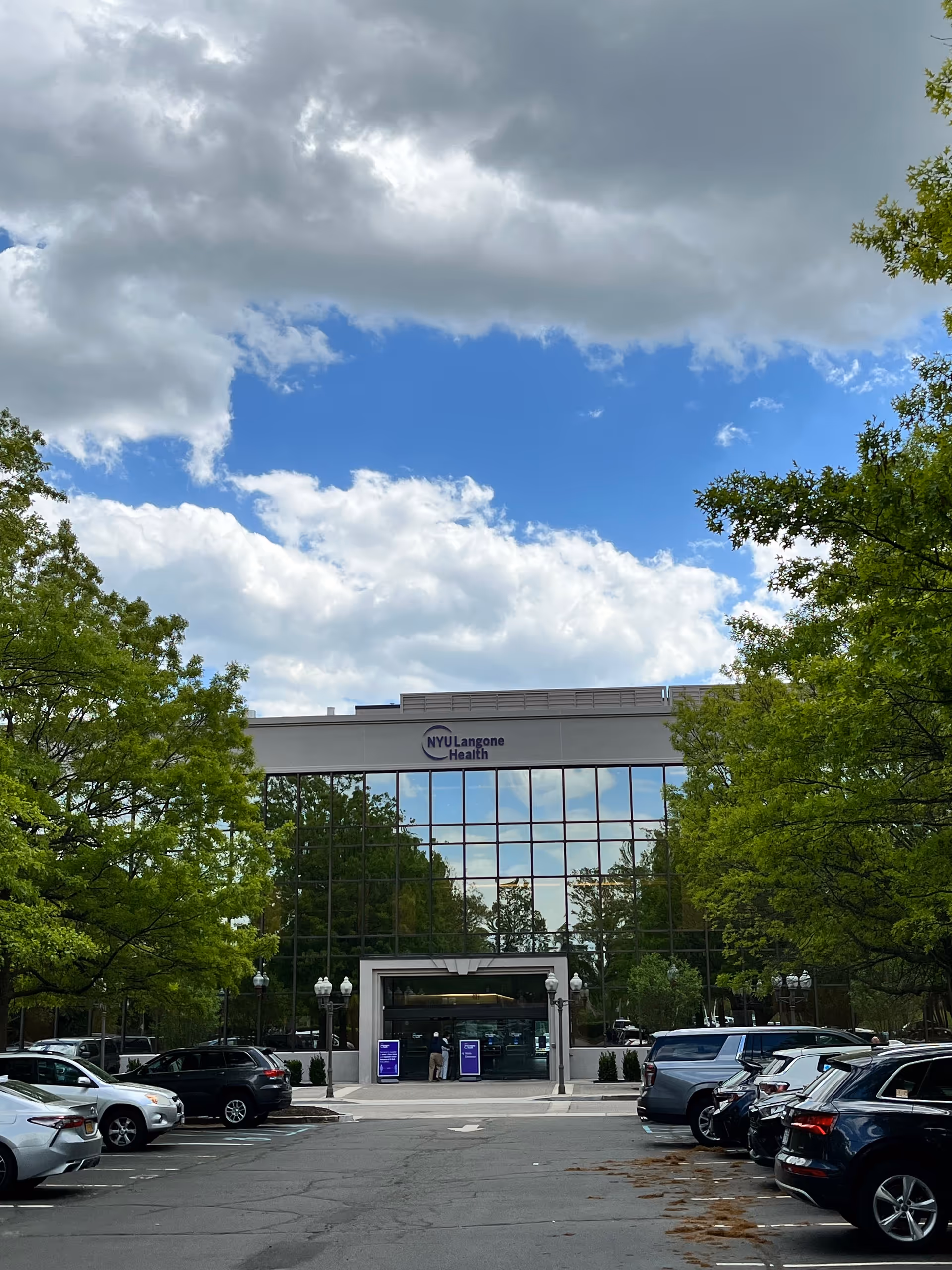 Exterior view of NYU Langone Health Bethpage building with glass entrance and trees