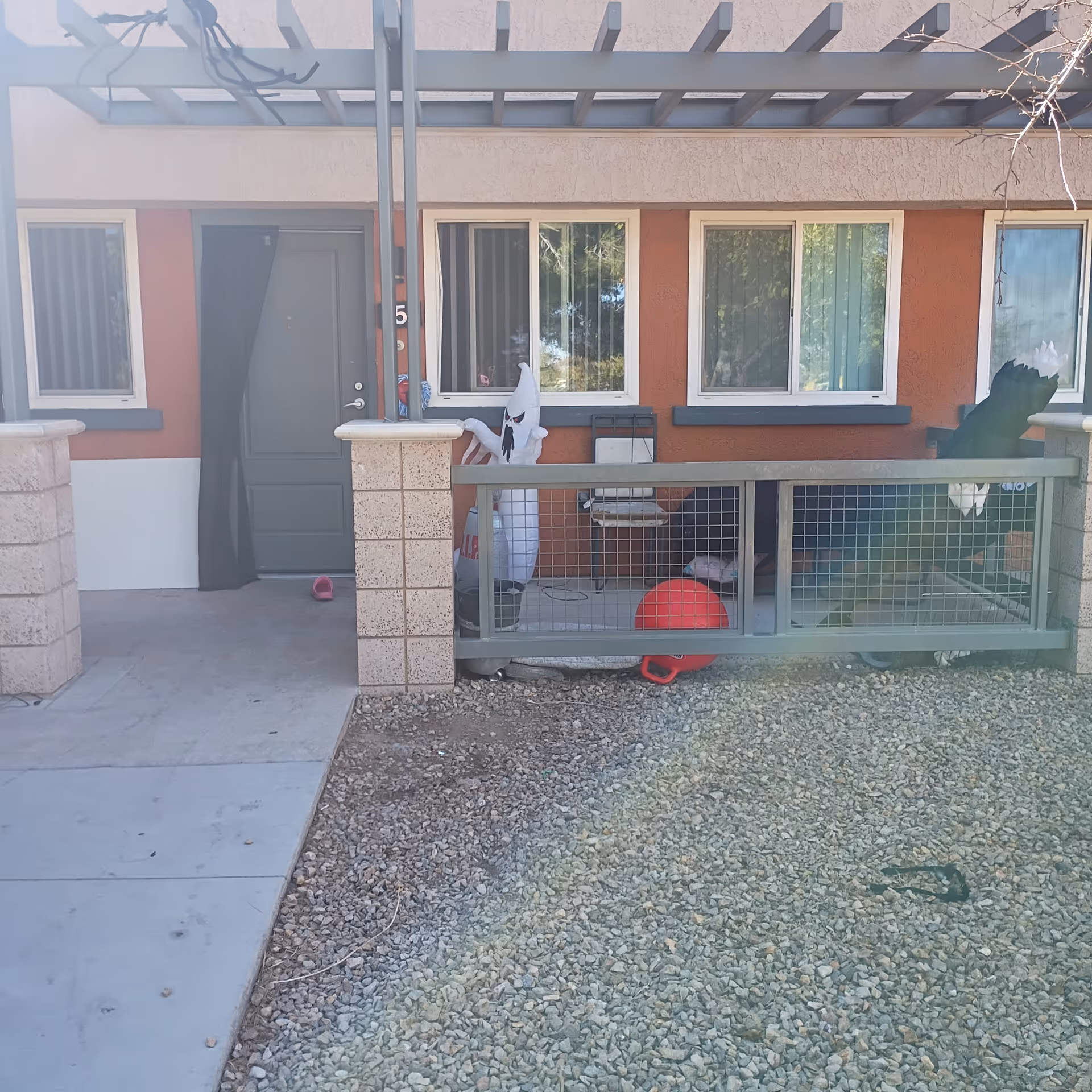 Front exterior of a red-orange senior living unit with a small porch.