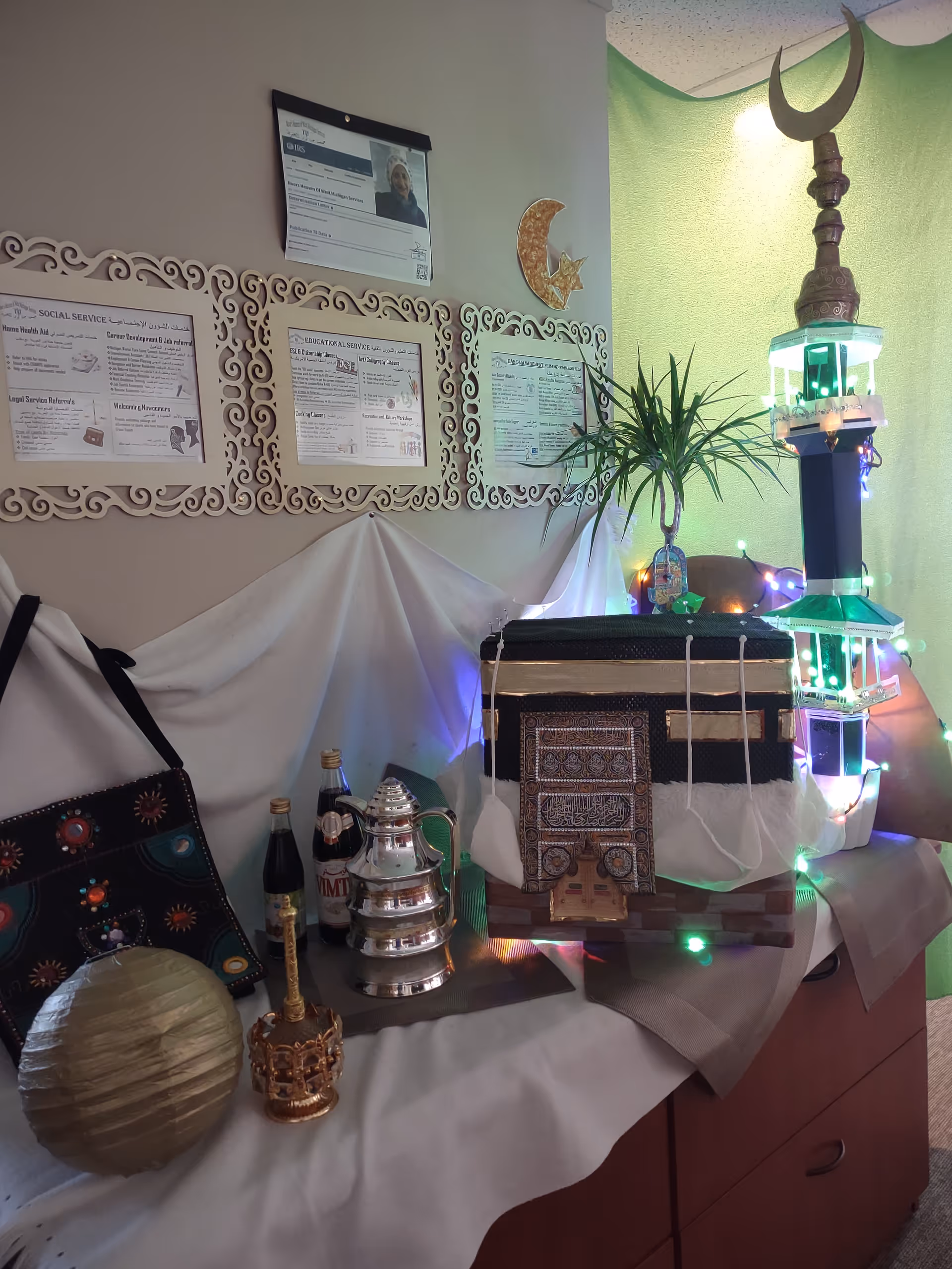 Decorative table display with ceremonial items beside wall of framed informational plaques.