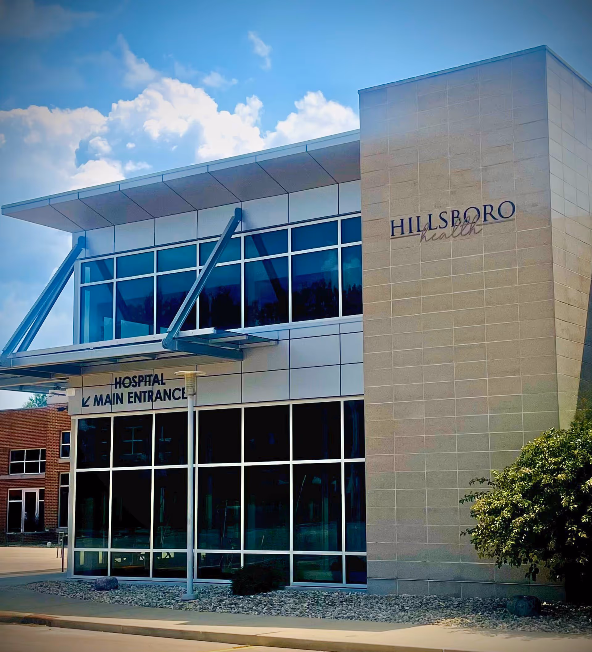 Modern Hillsboro Health hospital exterior with glass facade and main entrance.