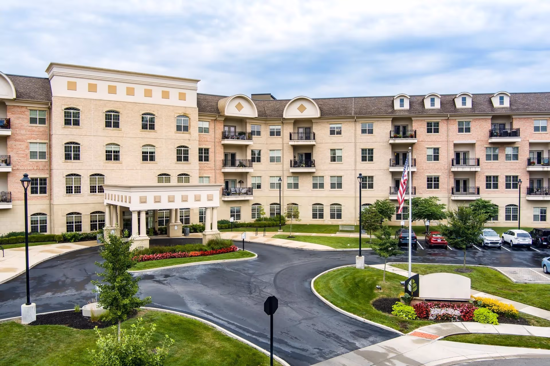 Exterior view of Woodland Terrace of Carmel with circular driveway and landscaped entrance.