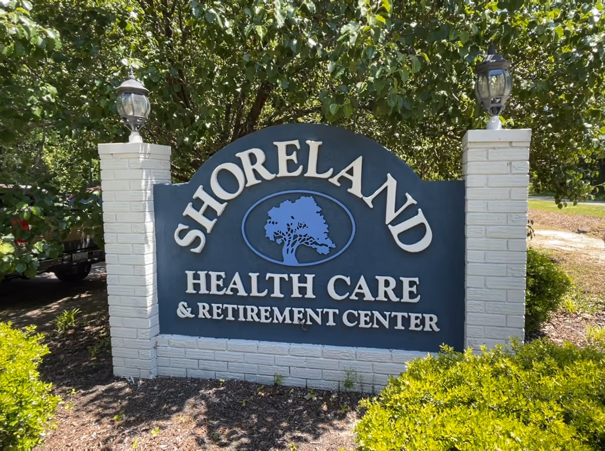 Large Shoreland Health Care and Retirement Center sign with trees