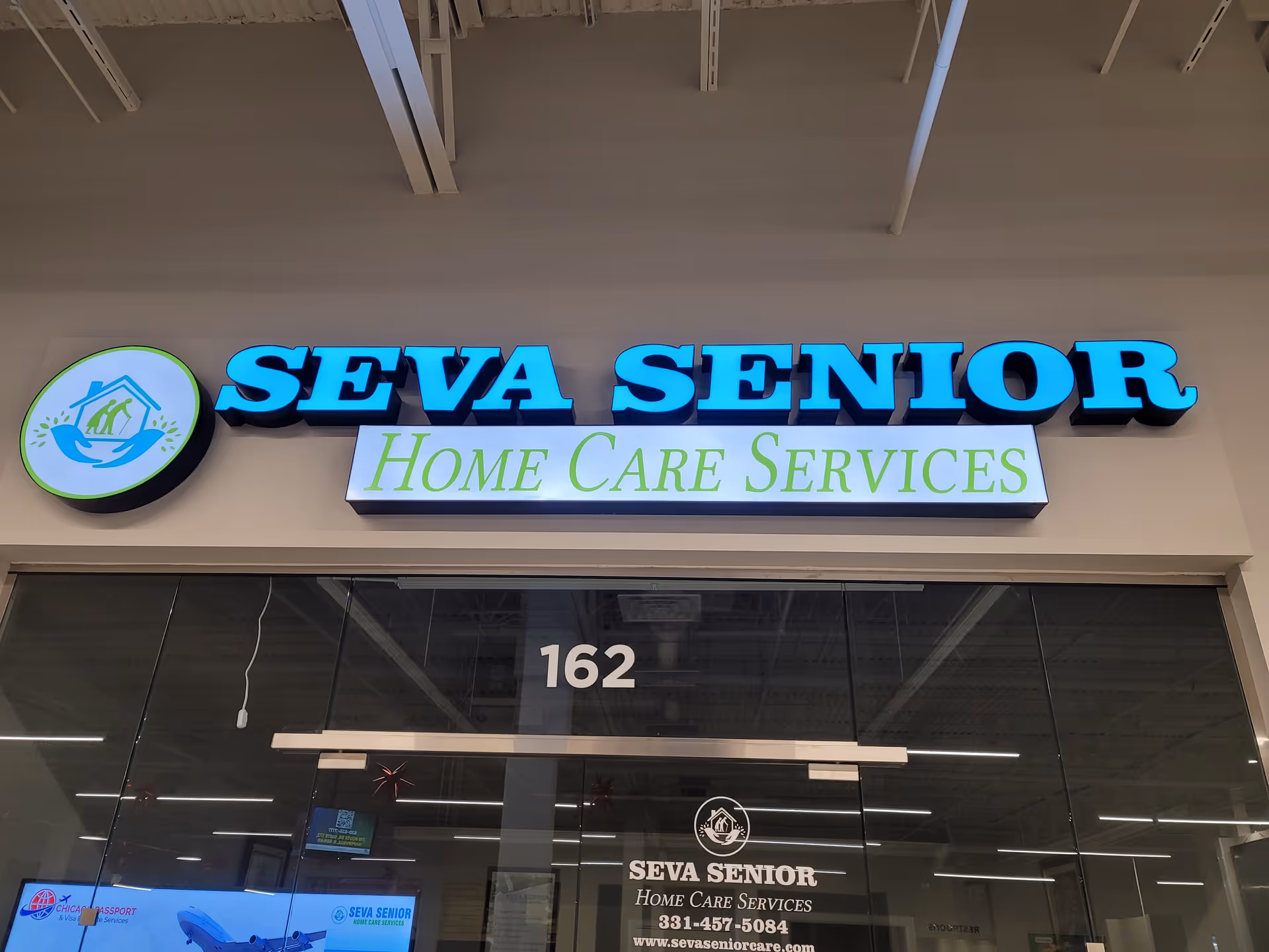 Seva Senior Home Care Services storefront sign sits above glass doors.