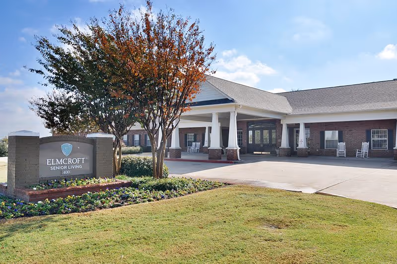 Exterior view of a senior living facility's front entrance with landscaping.