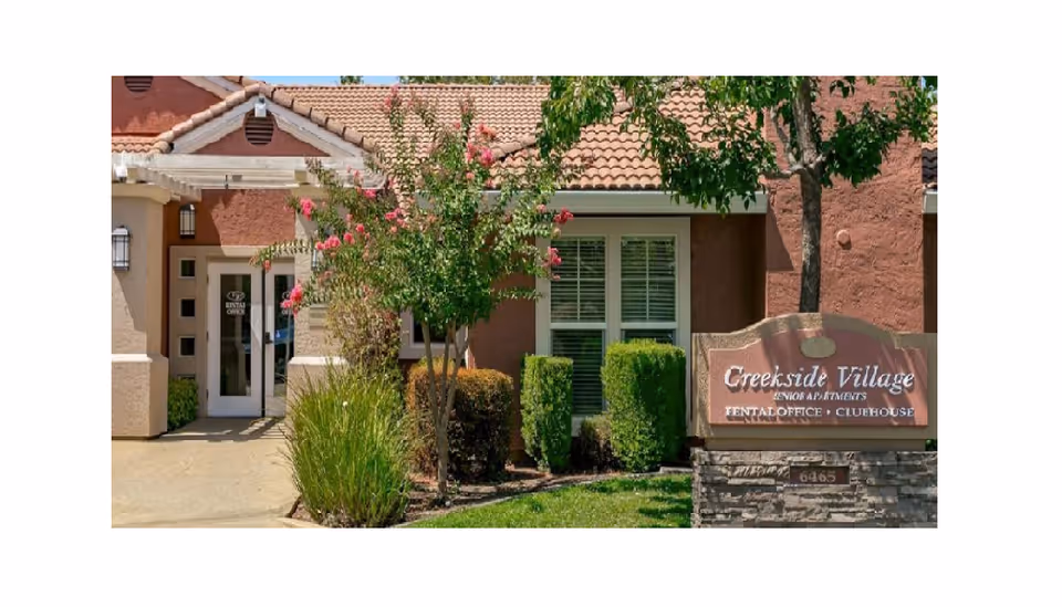 Exterior view of Creekside Village Apts entrance with landscaping