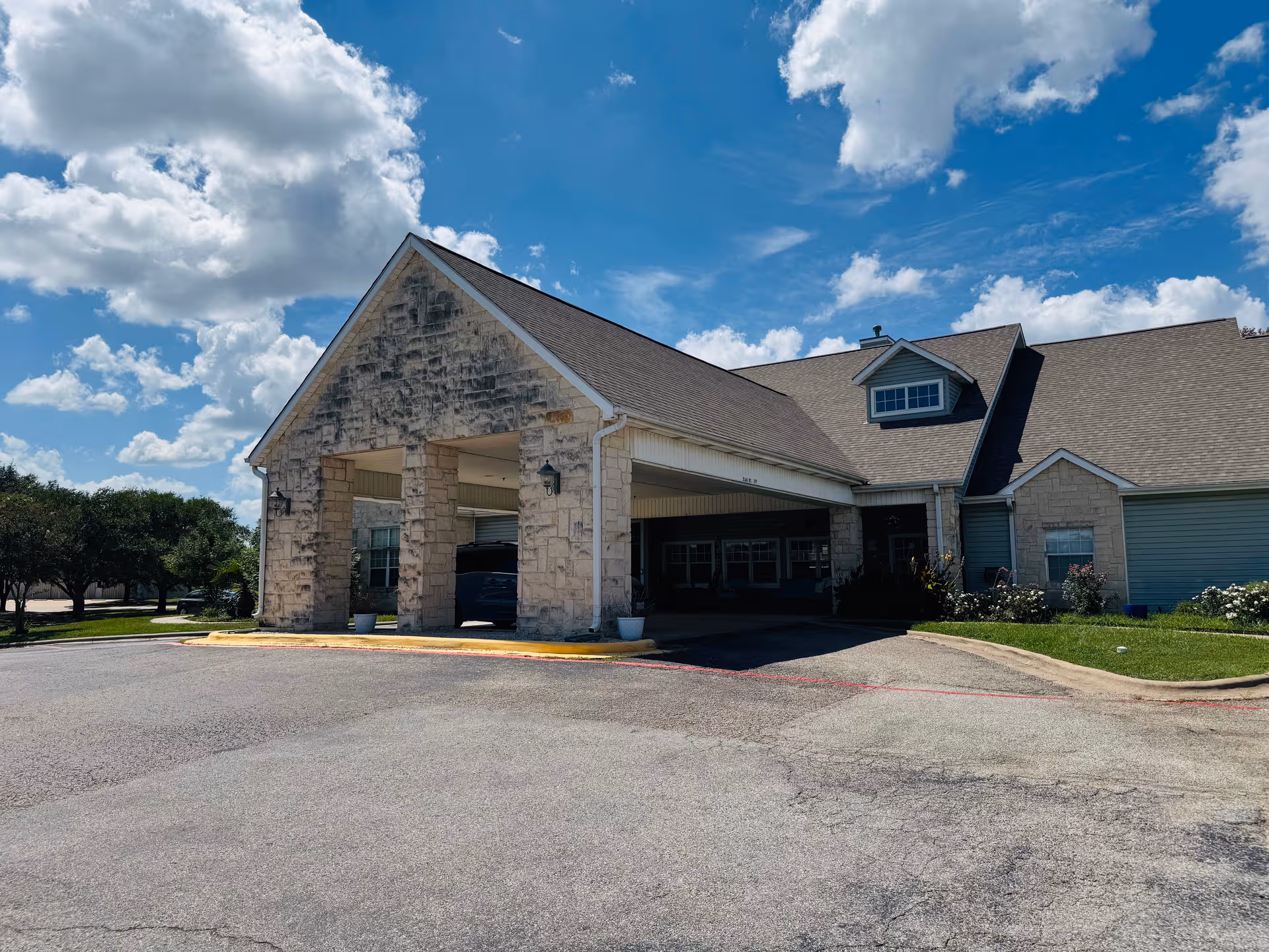 Exterior view of Argent Court Assisted Living, a stone-faced building with a covered entrance.