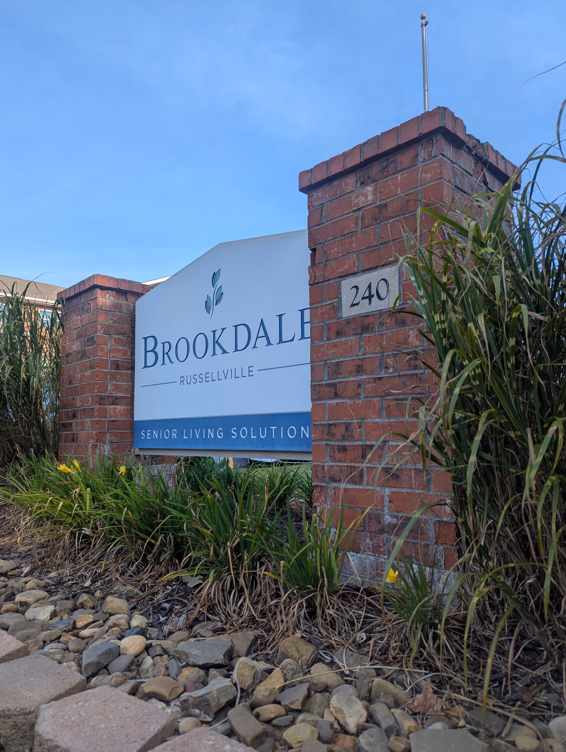 Brookdale Russellville exterior sign with brick pillars and landscaped entrance.