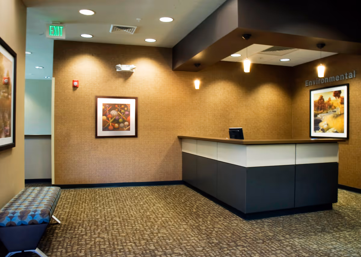 Interior lobby with reception desk, wall art, and patterned carpet.