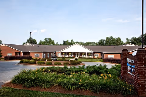 Front view of North Pointe of Asheboro senior living facility with landscaped entrance.