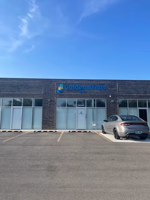 Exterior view of Golden Steps ABA building with a parked car in front.