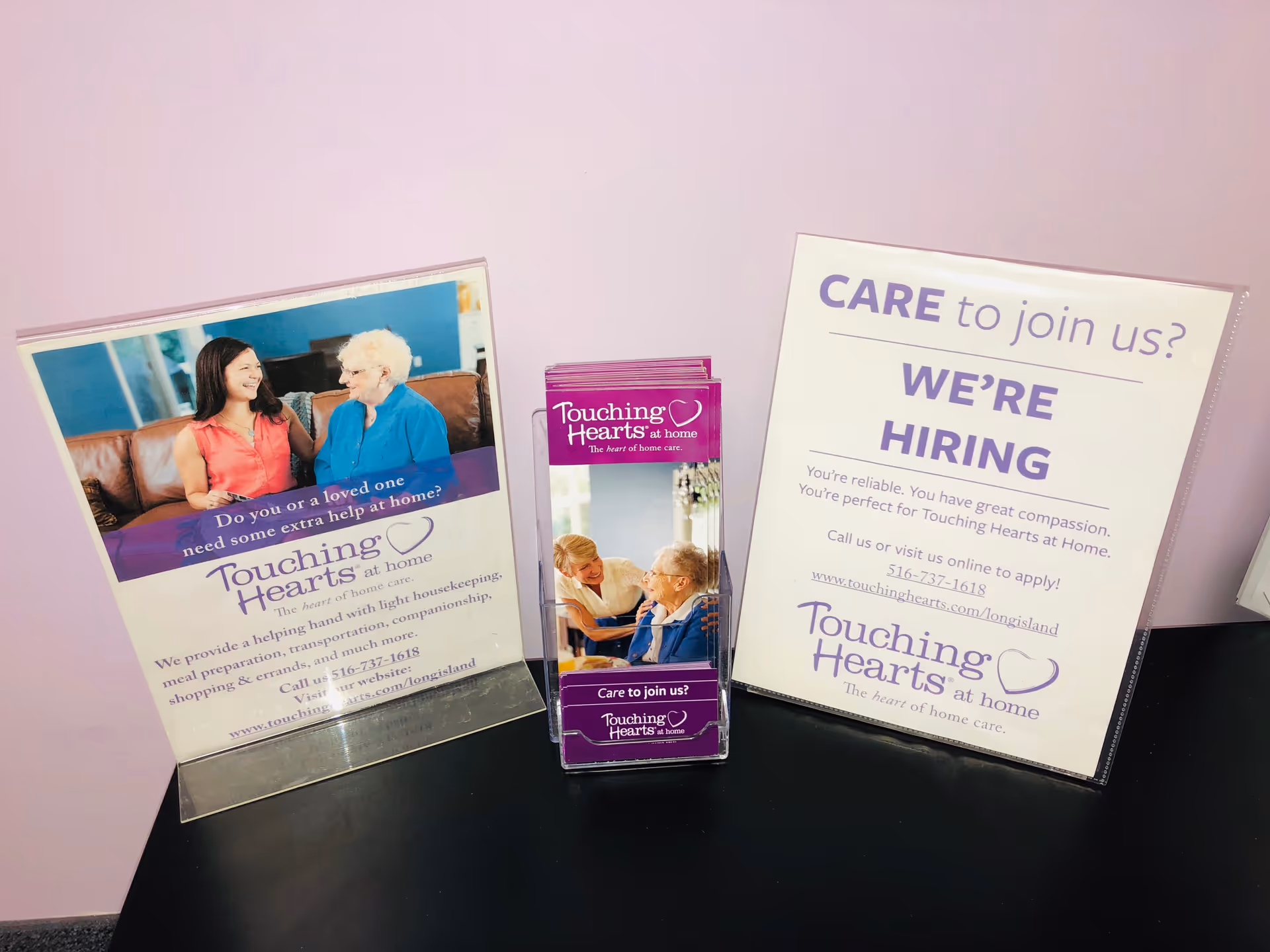 Interior display with Touching Hearts at Home posters and a brochure stand.