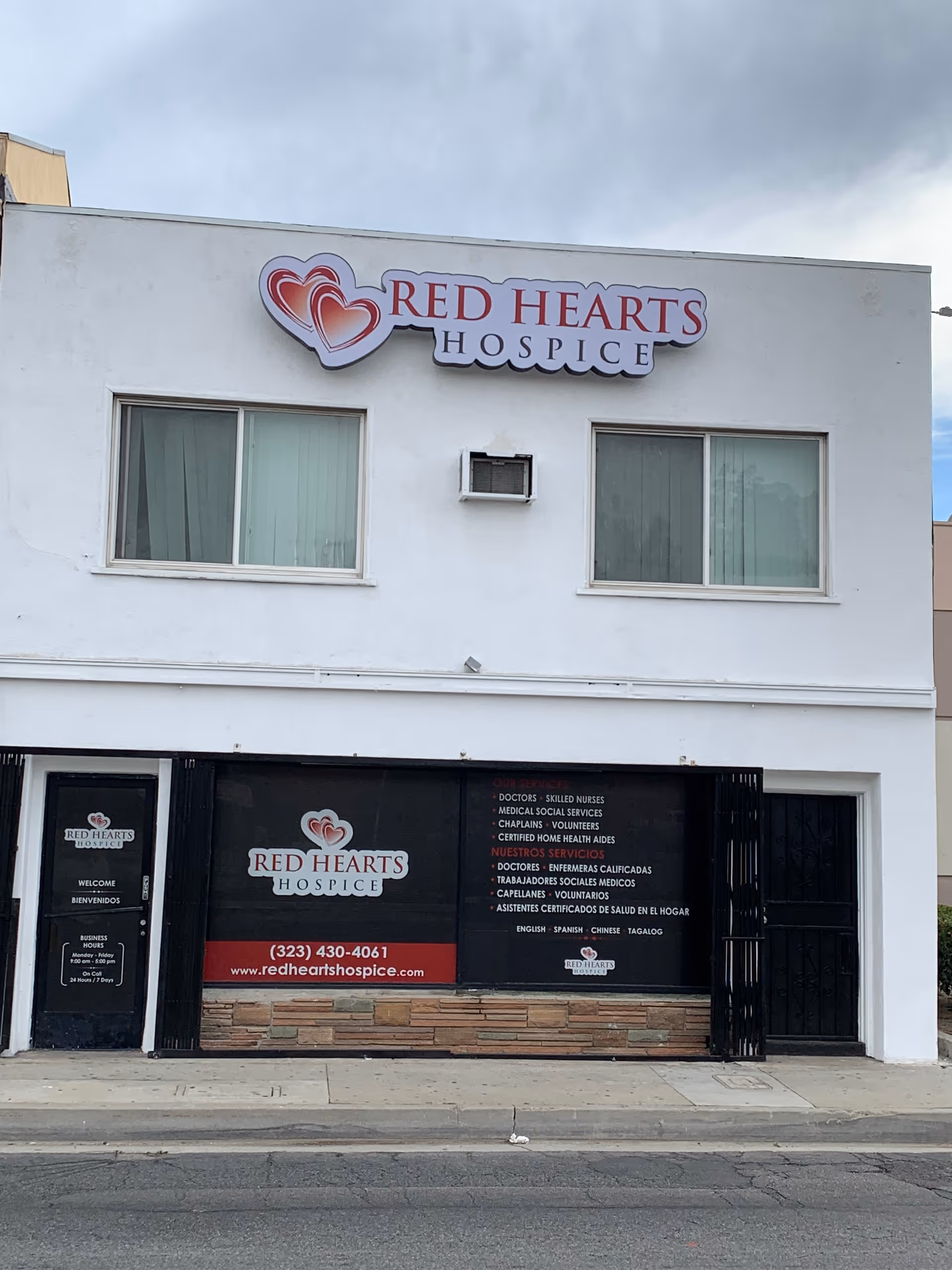 White two-story building with Red Hearts Hospice signage on the facade.
