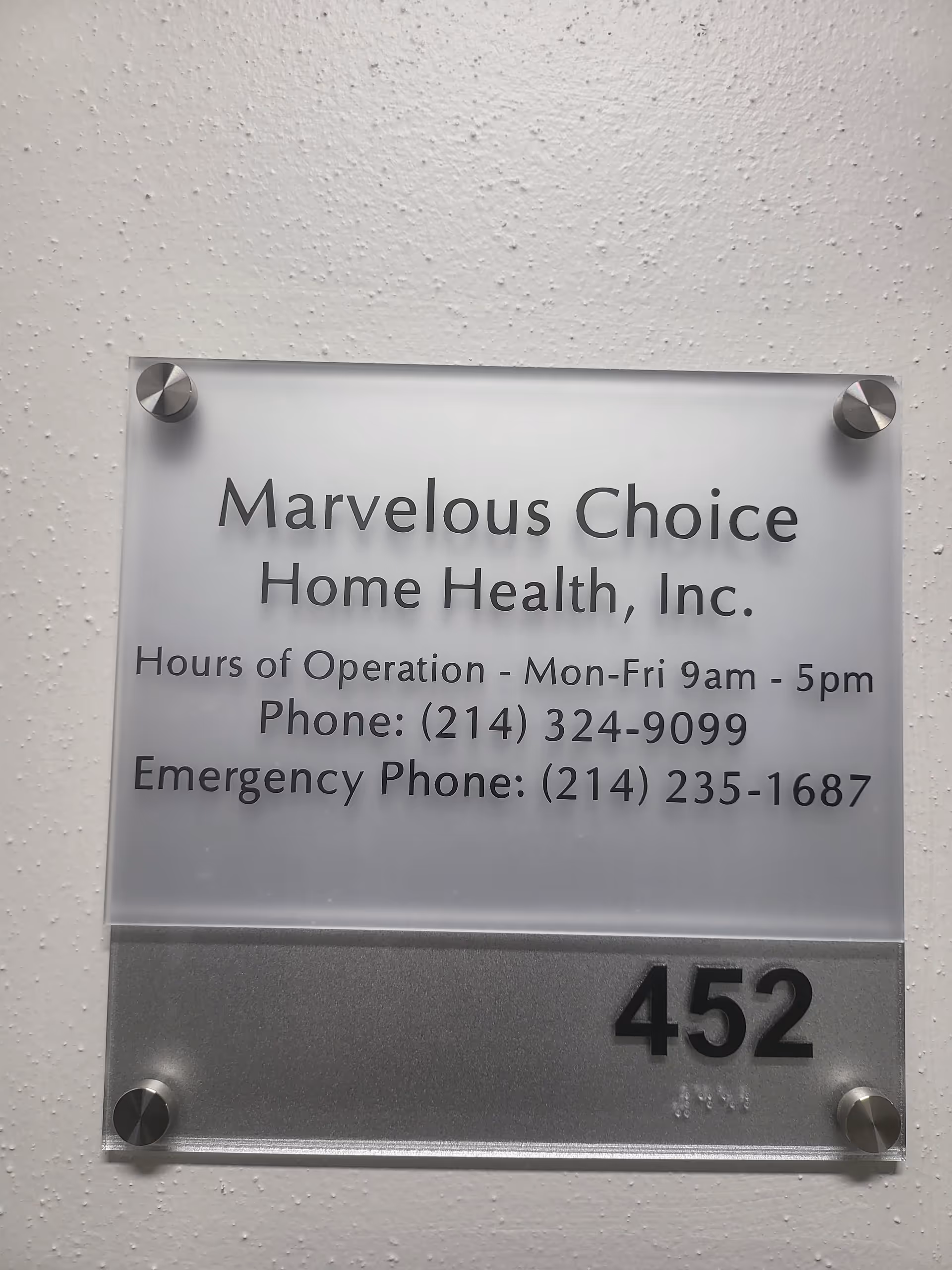 Metal plaque on textured wall displaying Marvelous Choice Home Health, hours and contact.