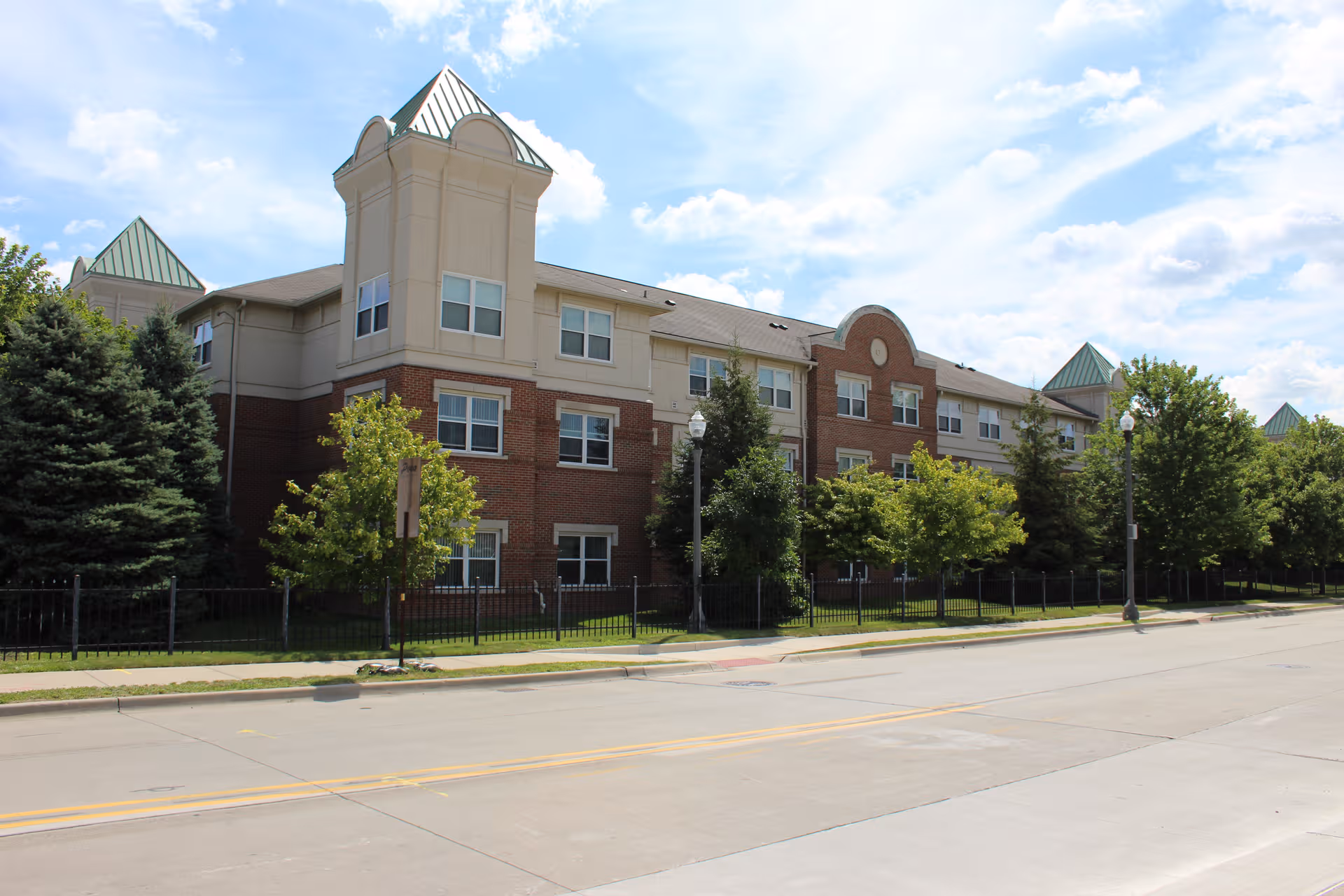 Exterior view of Village-Brush Park Manor, a multi-story senior living building with green roofs.