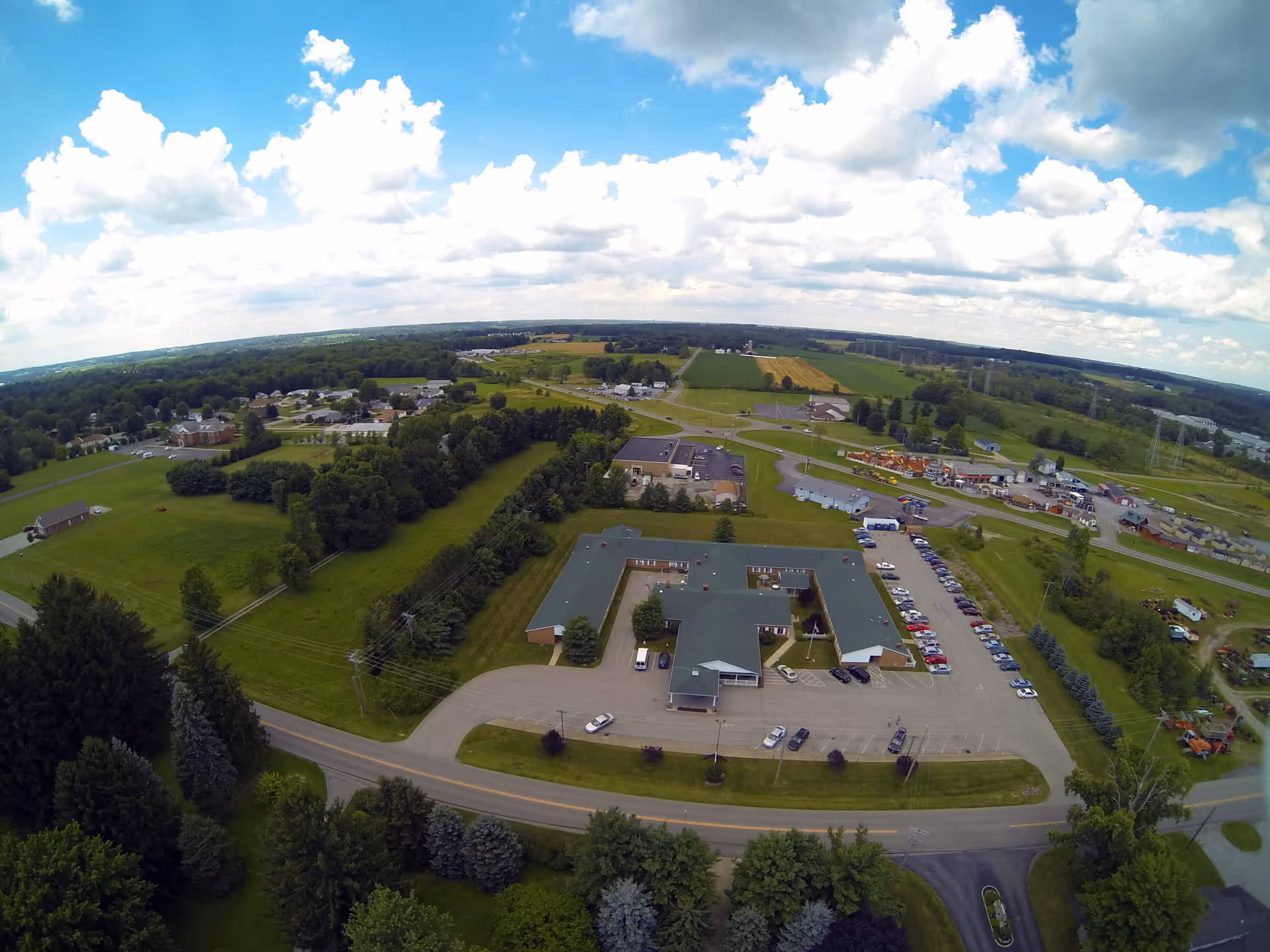 Aerial view of Windsor House exterior, showing the parking lot and green countryside.