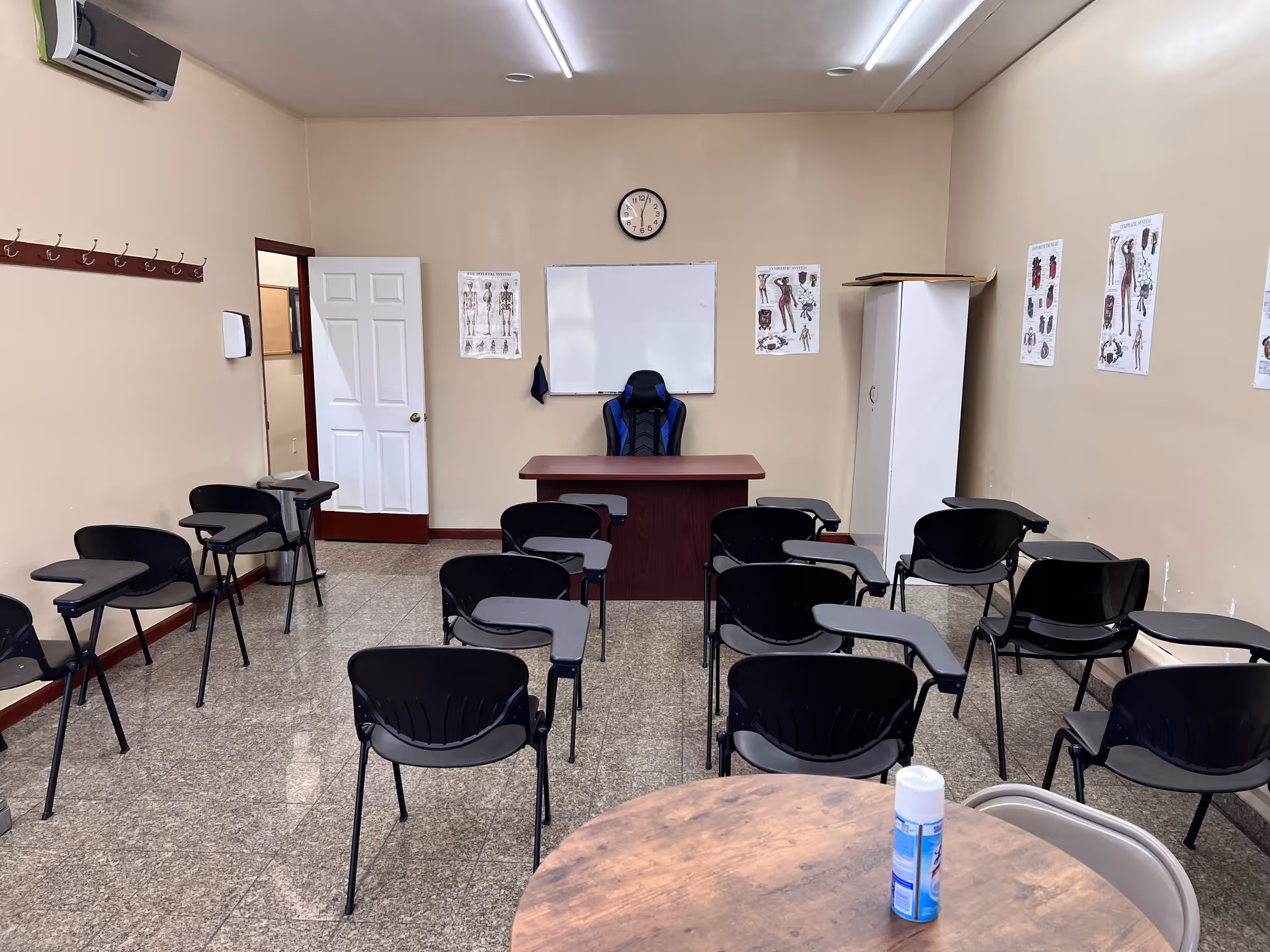 Classroom-style training room in a senior facility with a front desk, whiteboard, and posters.