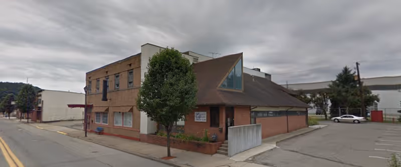 Exterior view of Trinity Home Health building with brick facade and triangular glass entry.