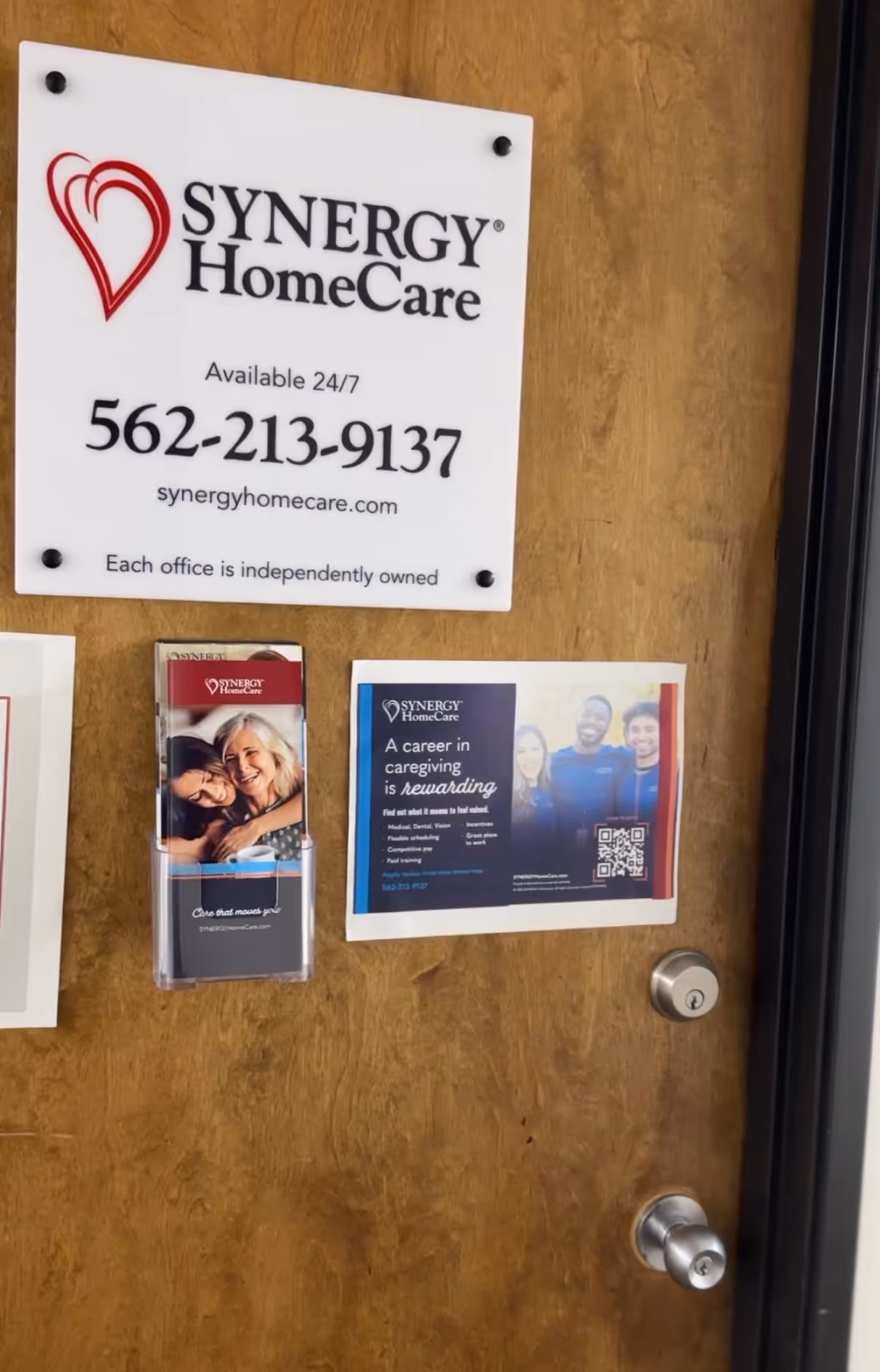 Wooden interior door with Synergy HomeCare sign and attached pamphlets