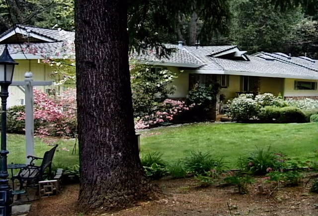 Outdoor view of Banner Crest facility with lawn, trees, shrubs, and seating near the building.