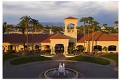 Clark Residence senior living facility exterior with fountain, circular driveway, and palm trees.