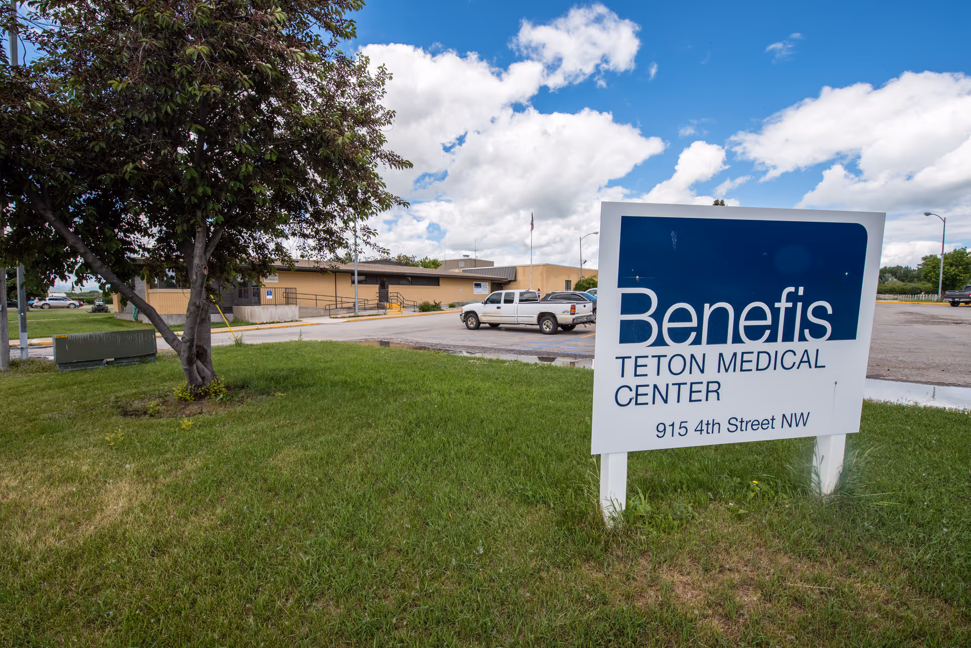 Outdoor view of the Benefis Teton Medical Center sign in front of a beige building