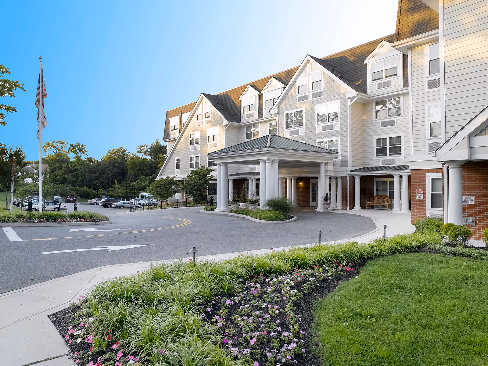 Exterior view of Atria Tanglewood with a portico, multi-story facade, and landscaped entrance.