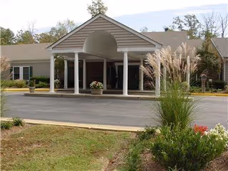 Front entrance of Vista Park Memory Care Center with columns and landscaping.
