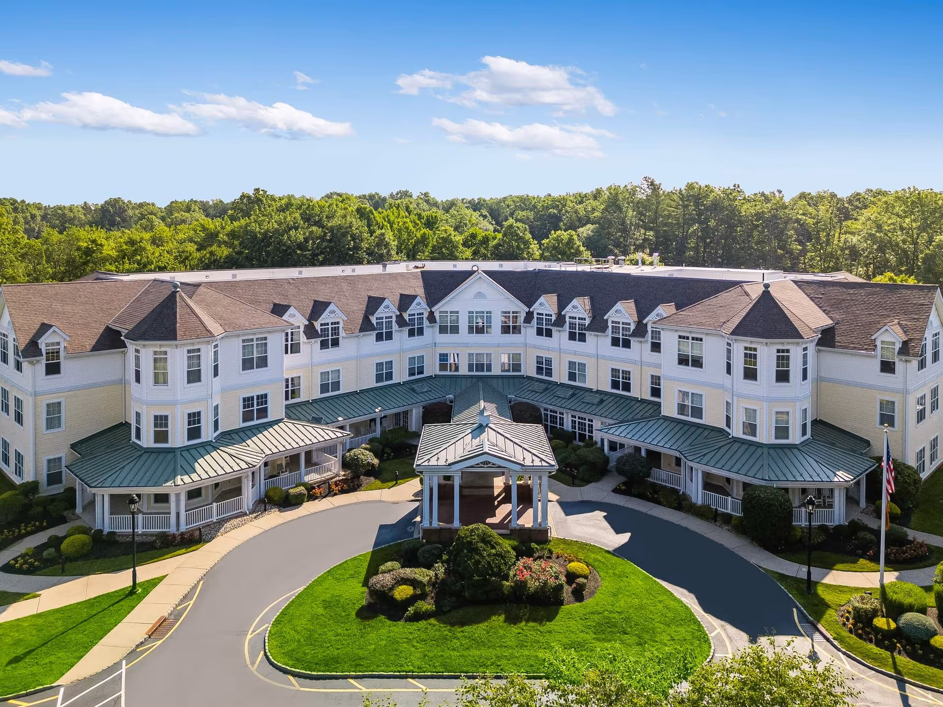 A large multi-wing senior living facility with a circular driveway and central entrance pavilion.