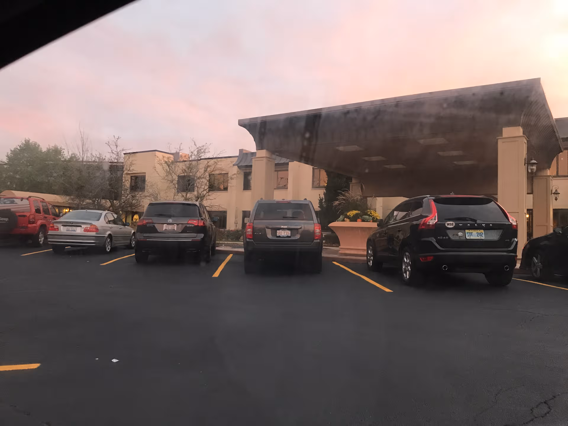 Parking lot in front of a senior living facility entrance with a covered drop-off.