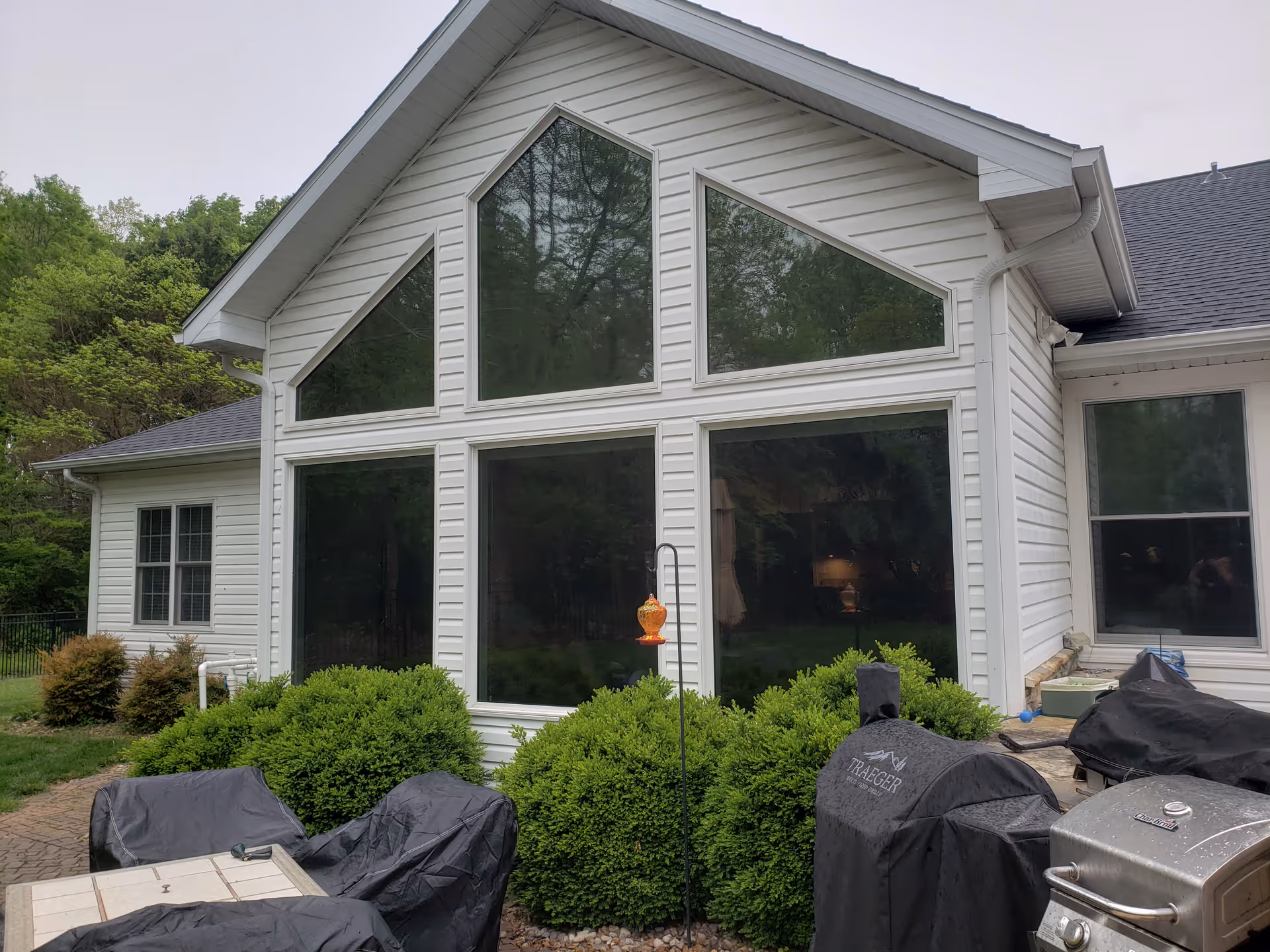 White senior living facility with large glass windows and a covered outdoor grilling area.
