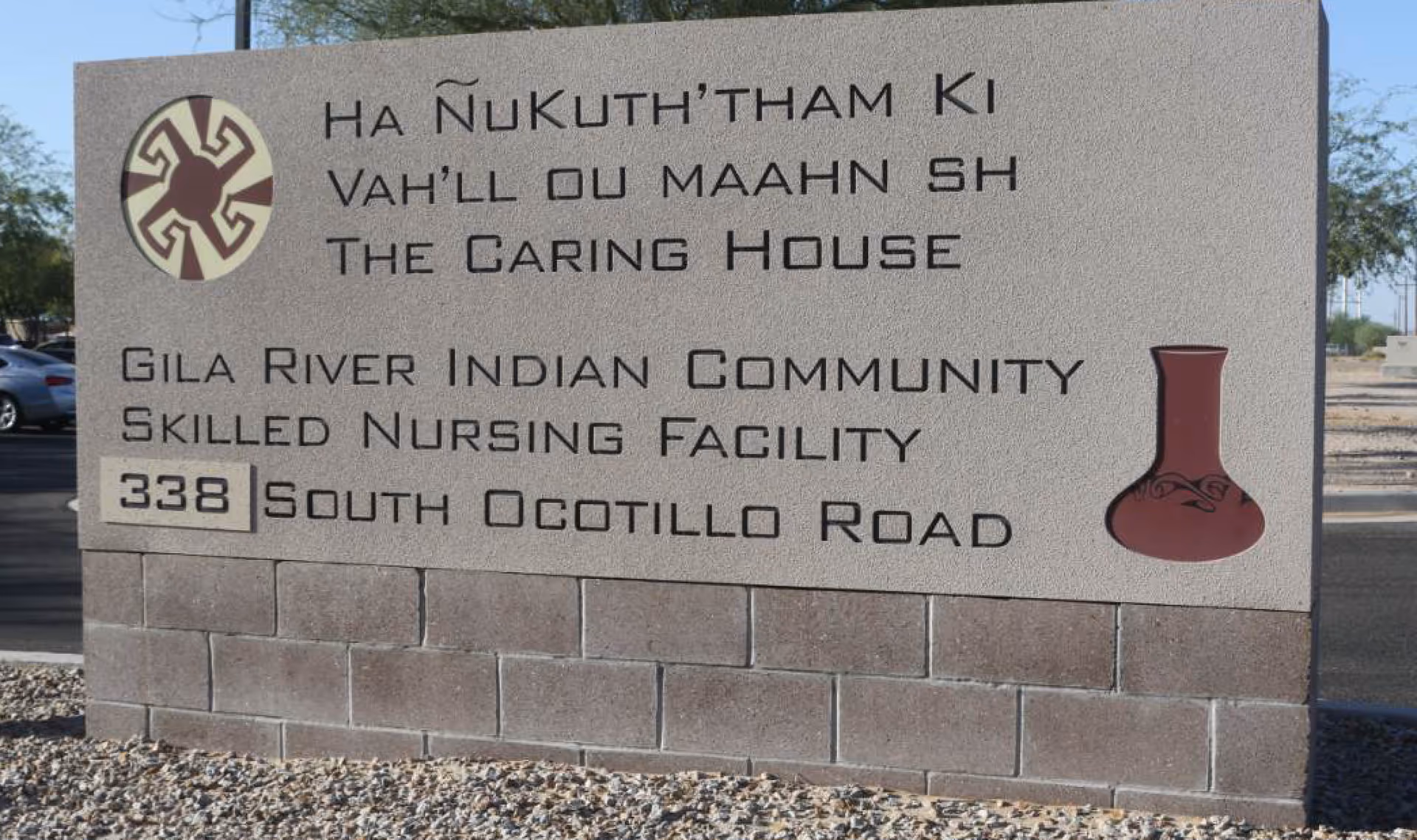A large stone sign advertising Gila River Indian Community Skilled Nursing Facility with address.