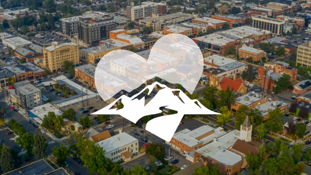 Aerial view of a city with a Big Sky mountain logo overlay.