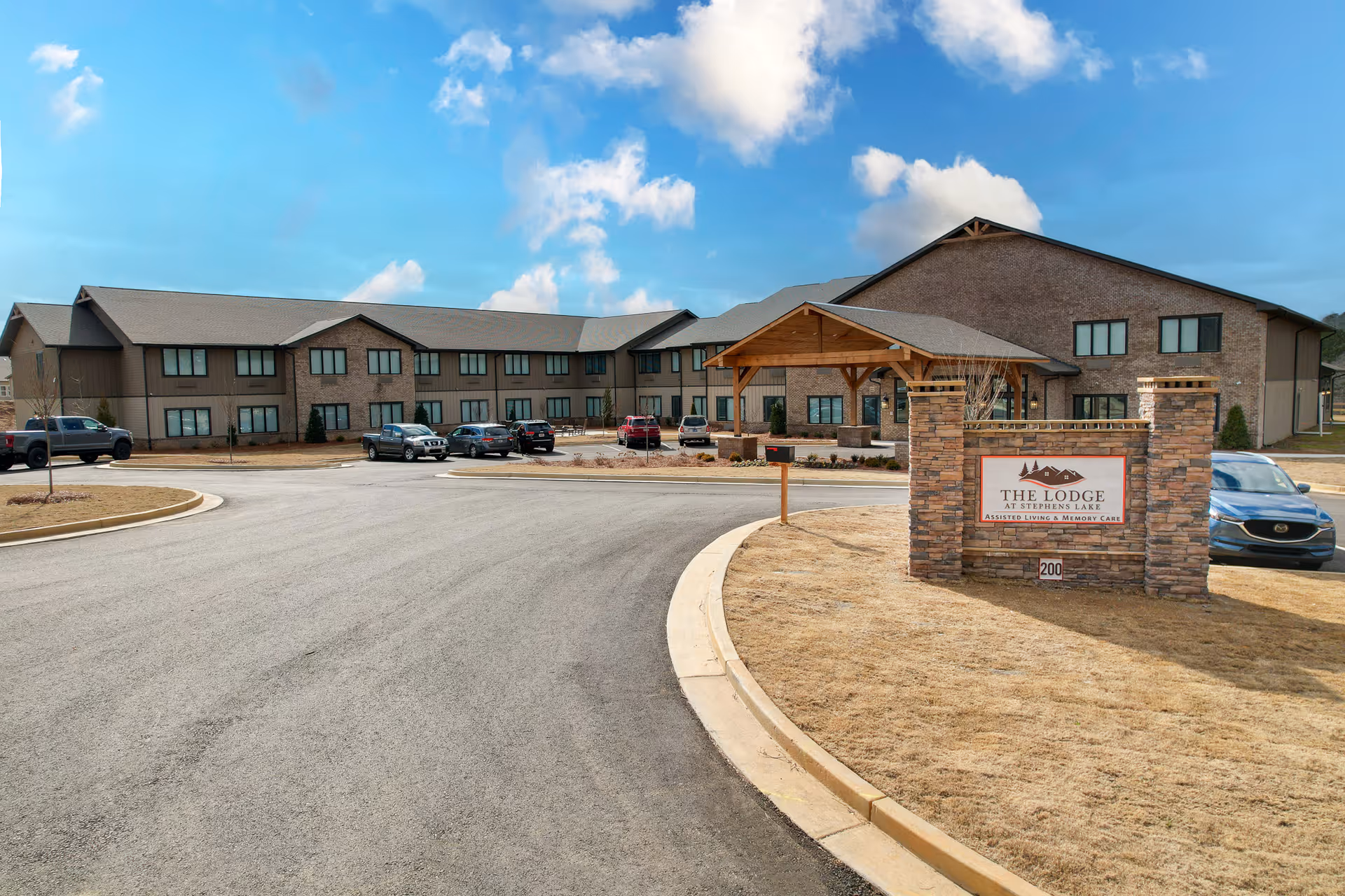 Exterior view of The Lodge at Stephens Lake entrance with brick building and sign.