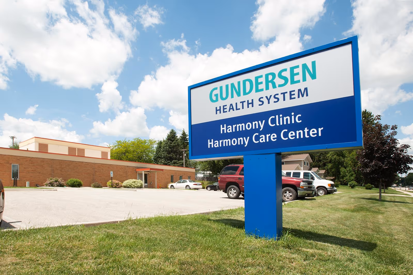 Exterior view of Gundersen Harmony Care Center sign in front of the building with cars.