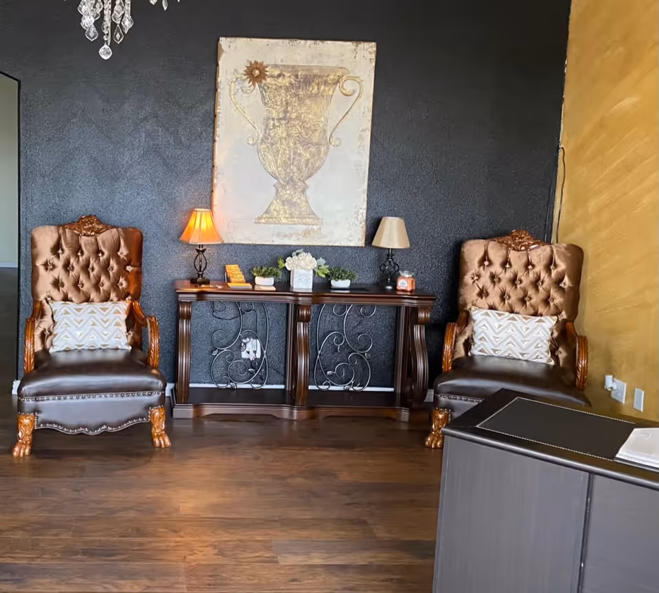 Two tufted leather chairs flank a decorative console table in a stylish living room.