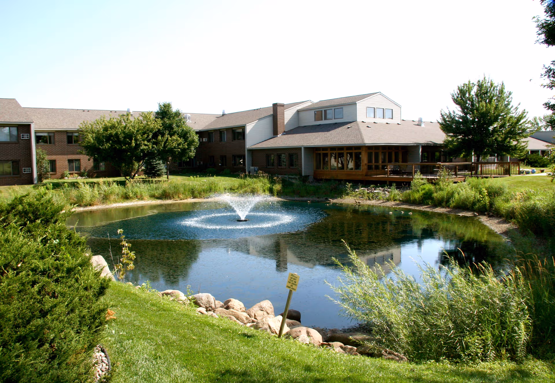 Exterior view of Country Manor Extended Service I with pond, fountain, and landscaping
